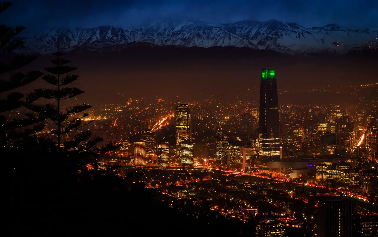 Santiago de Chile de noche: la ciudad iluminada y la cordillera de los Andes nevada al fondo