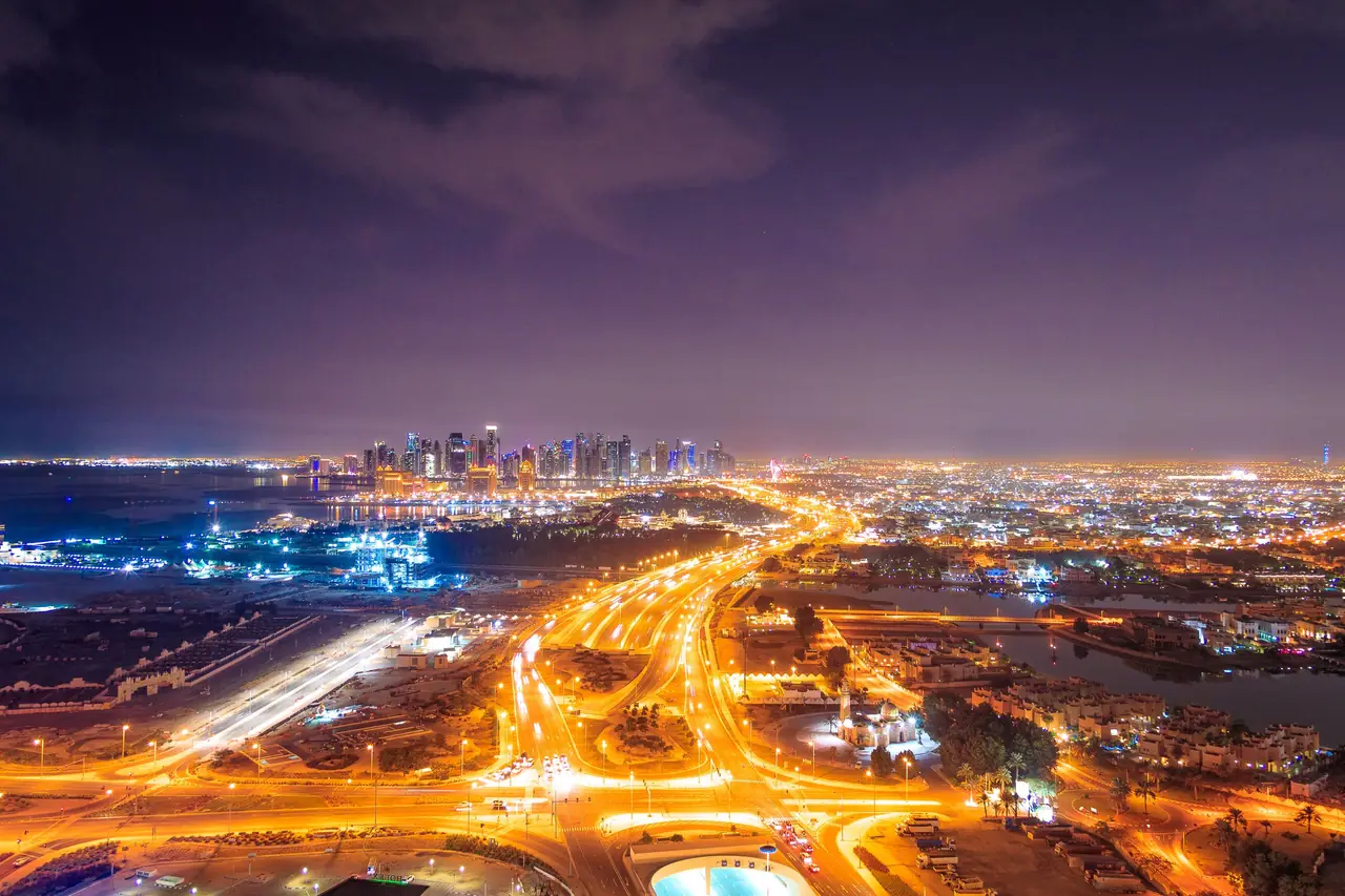 Doha, Qatar at night: lit highways and interchanges leading to the West Bay skyline