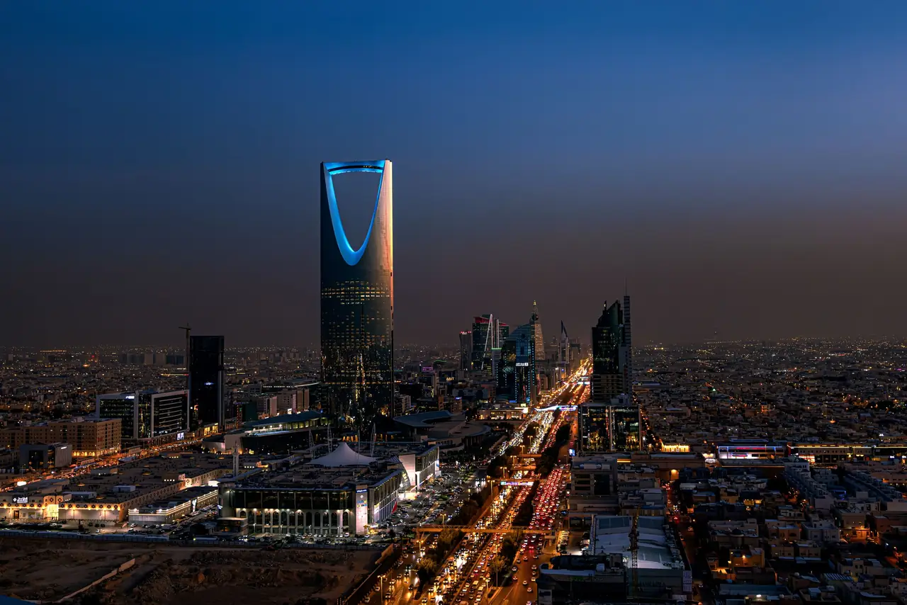 Riyadh, Saudi Arabia at dusk: evening traffic on a main road below the Kingdom Centre tower